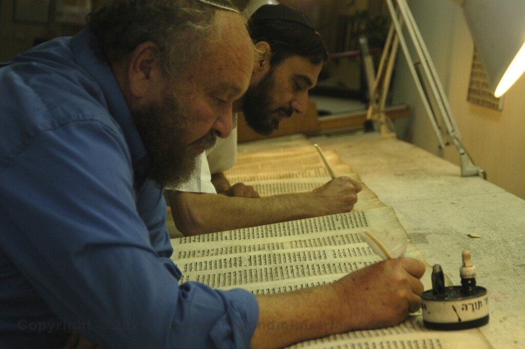 The Scribe Two Soferim repairing letters on a Torah Scroll at Macon OT in Jerusalem